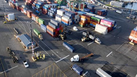 An aerial shot of a parking lot filled with trucks and containers. 