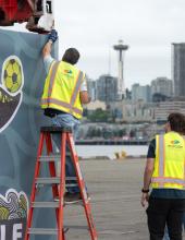 NWSA staff secure a FIFA banner on a shipping container at Terminal 46 in Seattle.