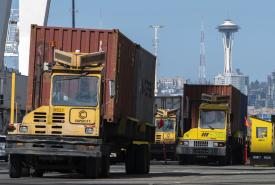 Three trucks carrying containers.