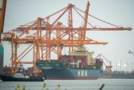 HMM Shipping Line vessel Hyundai Supreme is seen under ship-to-shore cranes at Washington United Terminals at the Port of Tacoma in December 2025. 